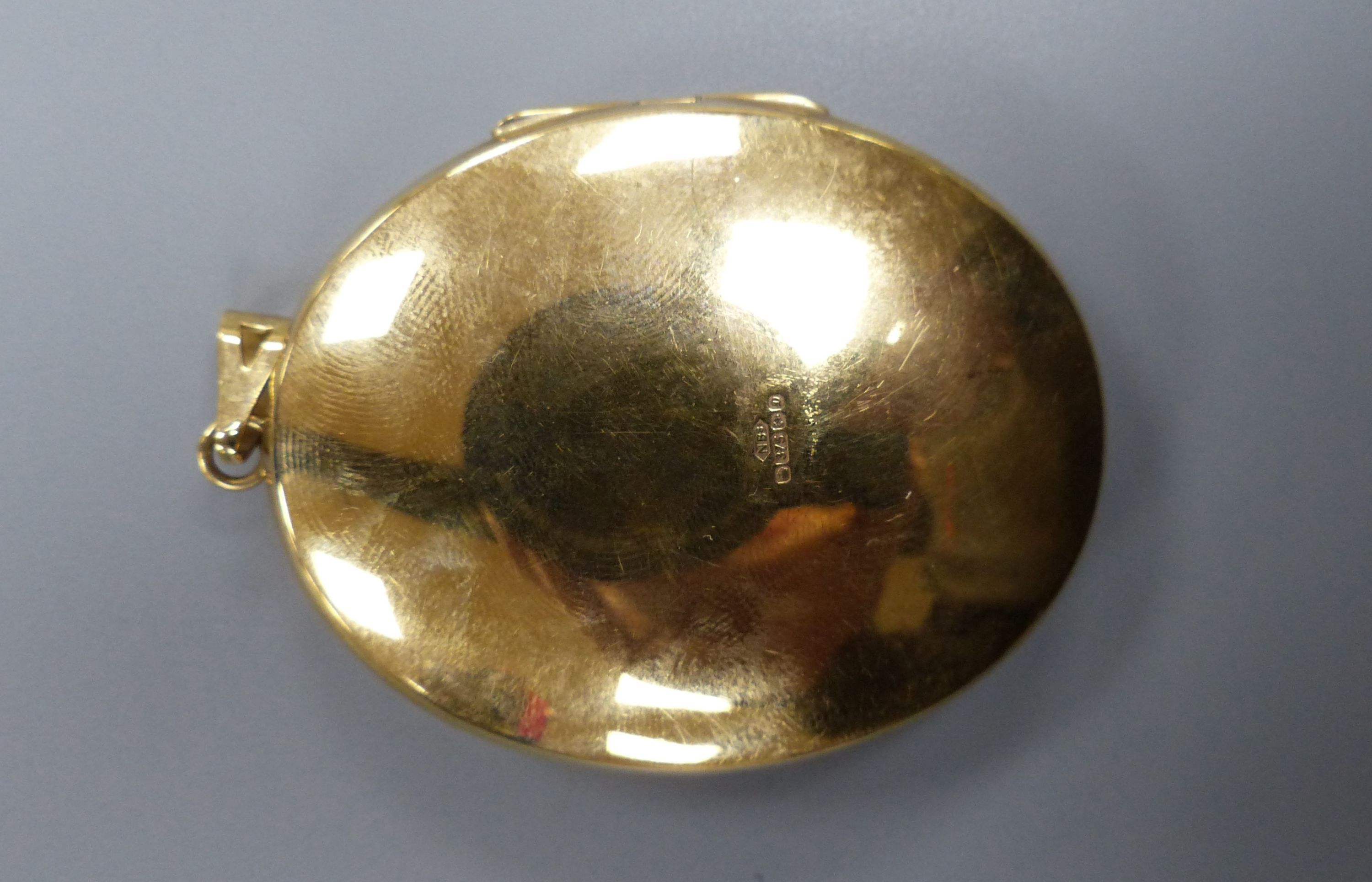A modern engraved 9ct gold oval locket, 47mm,